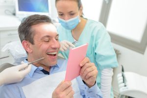 patient looks at dental restoration in mirror