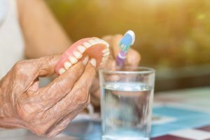 woman cleaning denture