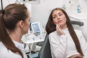 patient explaining jaw pain to dentist