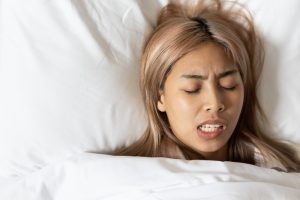 woman grinding teeth while asleep